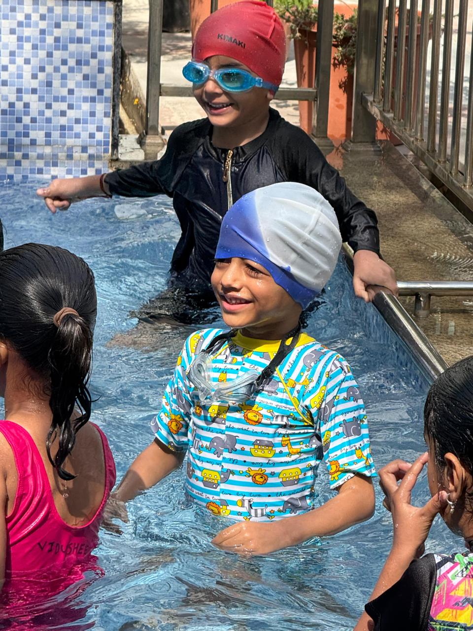 Children smiling together during swimming practice
