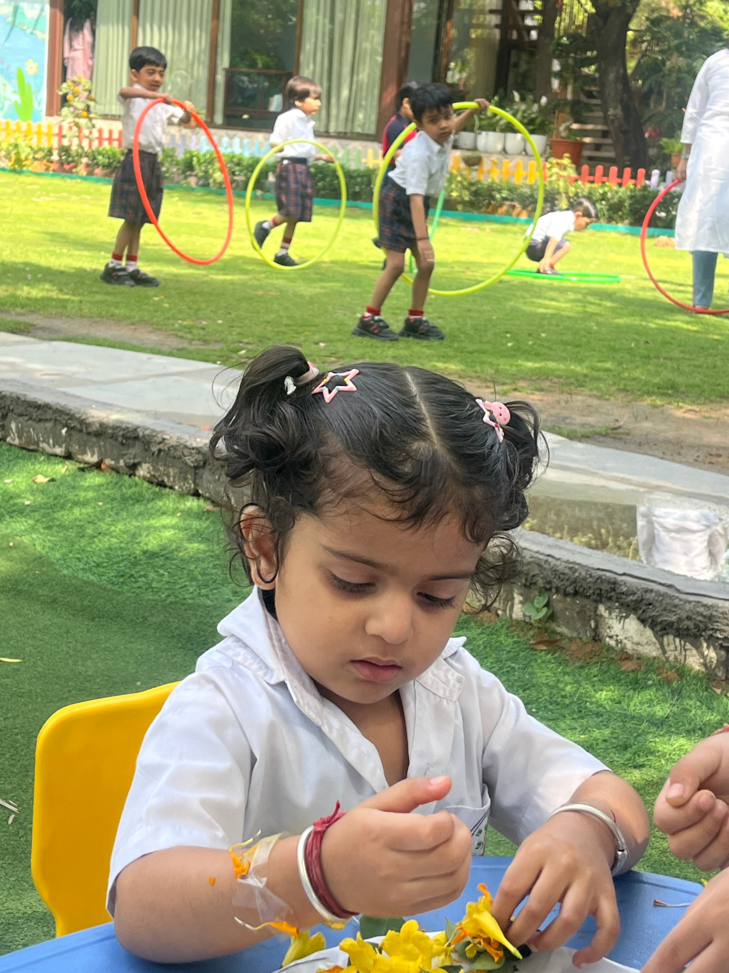 A little girl making a flower craft on the lawn