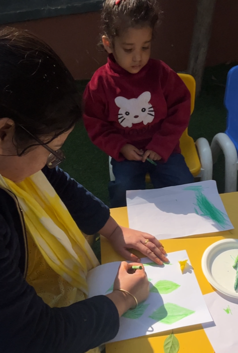 A mother guiding her toddler's crayon colouring at the table