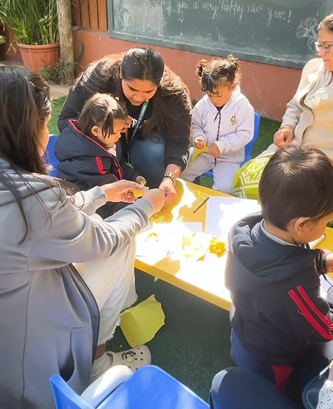 Teacher and toddlers at an outdoor activity table