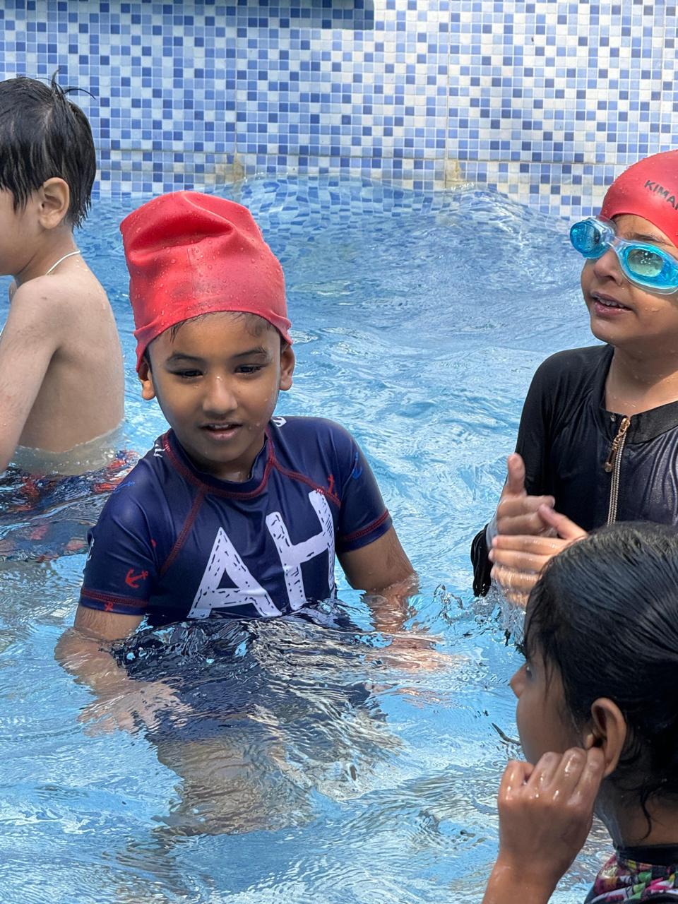 Children enjoying a supervised swimming session in the school pool