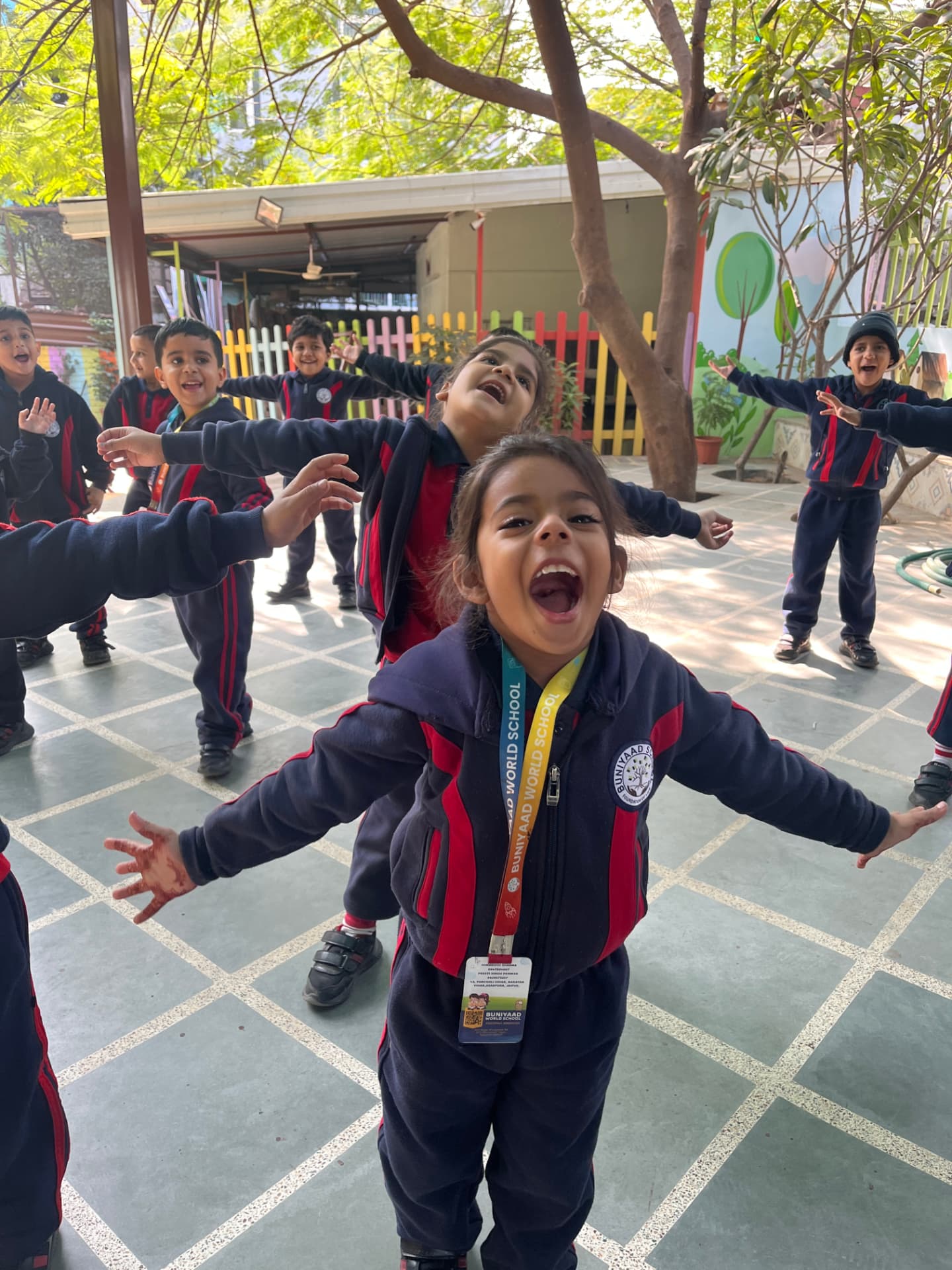 A boy dancing with arms wide open in the open-air courtyard