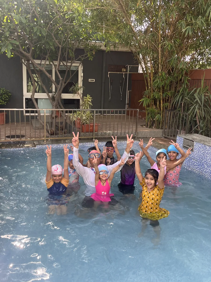 Children swimming in the school pool with their coach