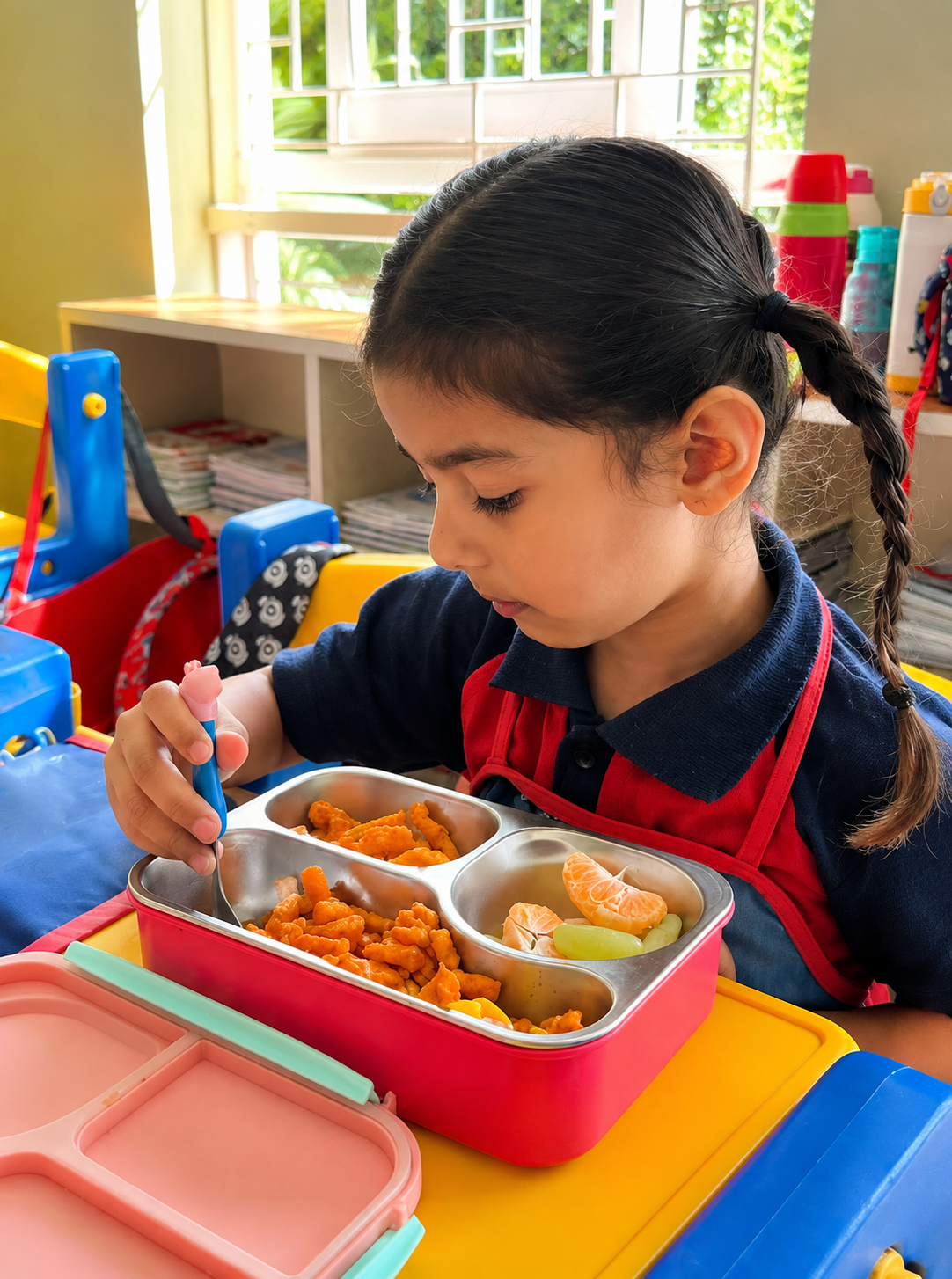 A girl eating her tiffin during the classroom snack break