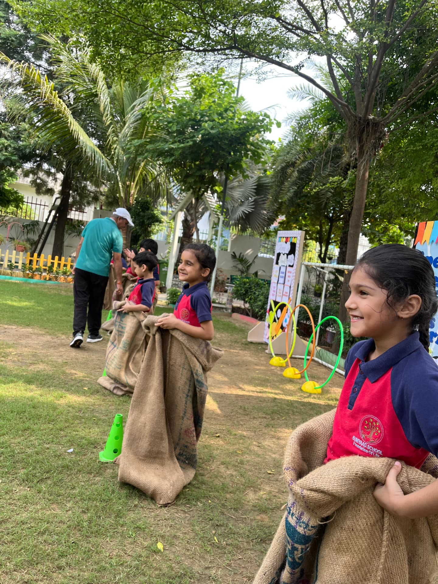 Children taking part in a sack race on the school lawn